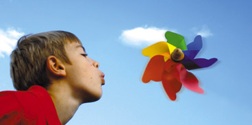 Boy blowing toy windmill
