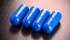 pillole blu su superficie di legno