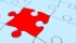 Tessera rossa di un puzzle in mezzo alle tessere bianche
