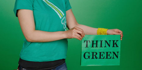 Ragazza tiene in mano un cartello con la scritta Think green