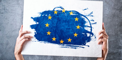 Persona tiene tra le mani un cartello con la bandiera dell'Unione Europea