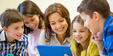 Maestra e bambini di fronte a un tablet