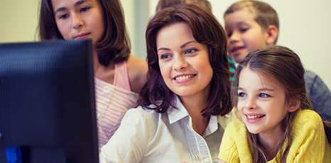 Maestra e bambini di fronte a un computer