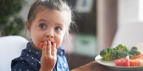 Una bambina mangia verdure