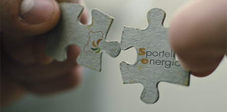 Immagine di due mani che reggono due tasselli di un puzzle con su il logo dello sportello energia