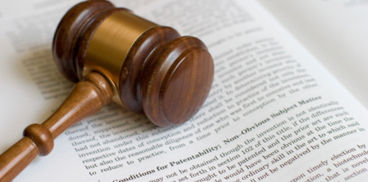 Libro sui brevetti e martelletto del giudice