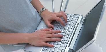 Addetta ufficio stampa digita sulla tastiera di un laptop