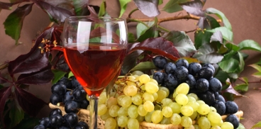 Grappoli d'uva e un calice di vino rosso