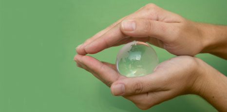 Mani che trattengono una sfera di cristallo raffigurante la Terra