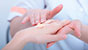 Applicazione di una crema sulla mano femminile