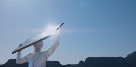 Persona mantiene un pannello fotovoltaico orientato verso il Sole