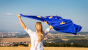 Donna sventola la bandiera dell'Unione europea in mezzo alla campagna