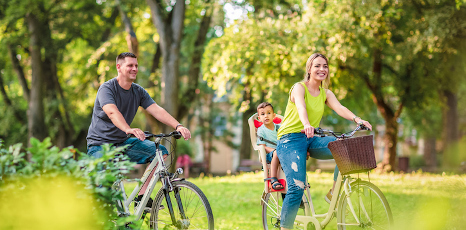 Famiglia in bicicletta al parco