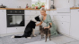 Una donna in cucina con un cane e un gatto