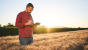 Agricoltore in un campo di grano con tablet